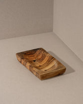 A rectangular natural olive wood soap holder with visible wood grain and draining holes.