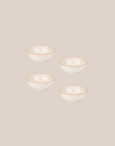 Four small white ceramic bowls with thin ivory rims, arranged in a loose grid on a solid light beige background.