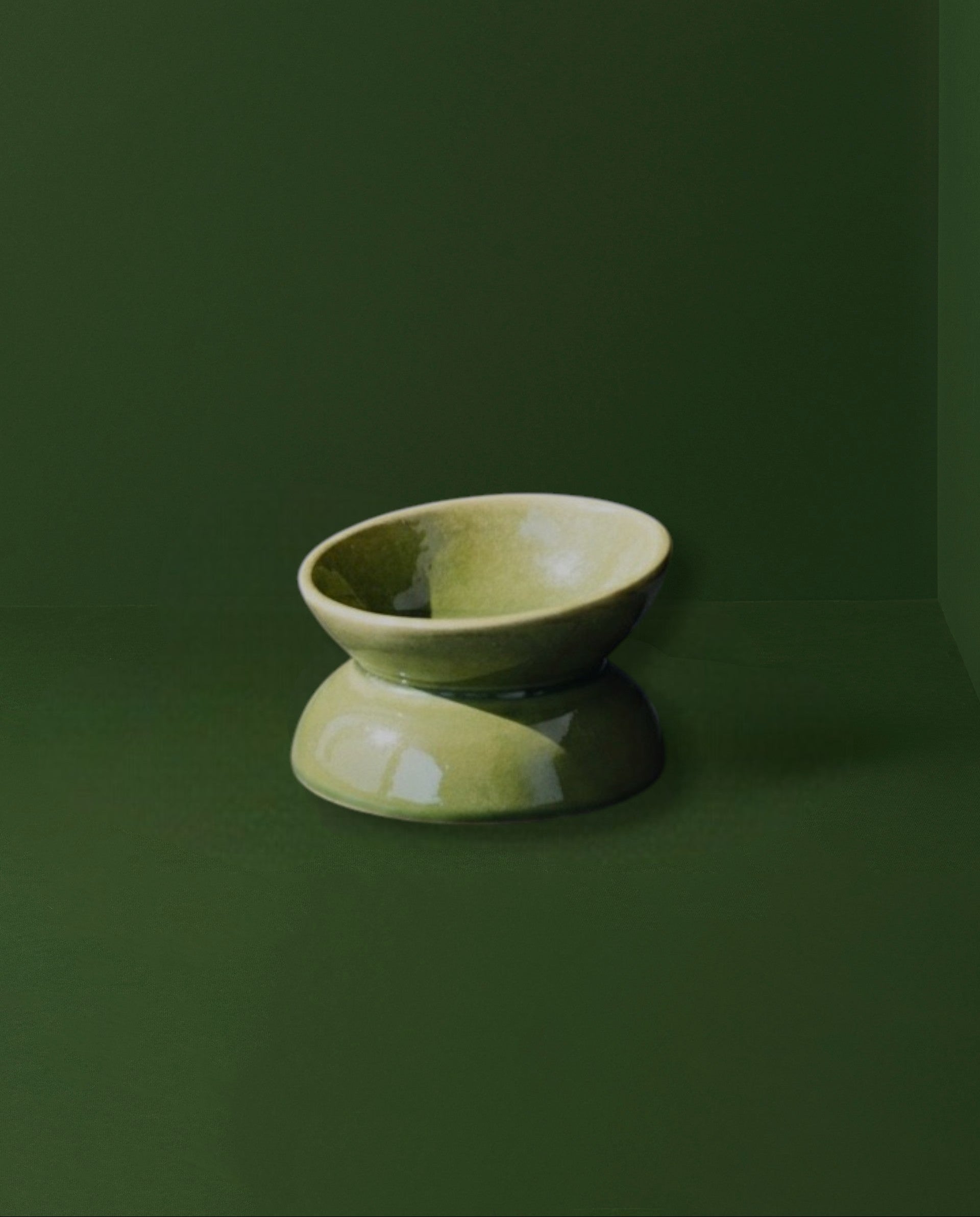 Green ceramic bowl on a dark green background