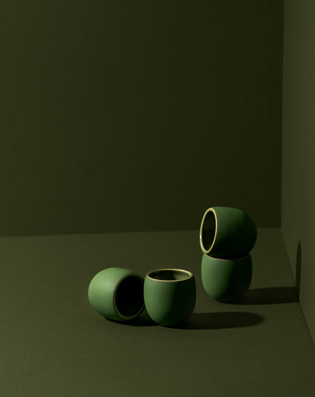 Four stoneware creamer cups in a matte finish, with one cup partially filled with a creamer, displayed against a neutral background.