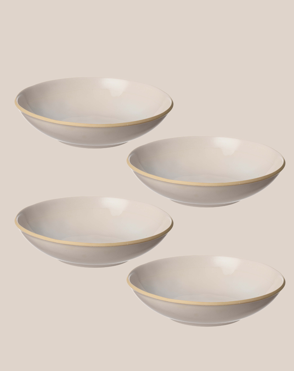 Four white ceramic bowls with a thin gold rim, arranged diagonally on a solid beige background.